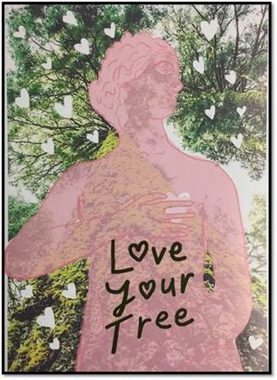 A woman with her hand over her heart in front of a tree